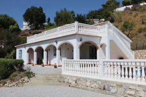 una gran casa blanca con barandilla blanca en Casa los Almendros, en Canillas de Albaida