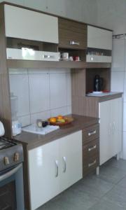 a kitchen with a plate of fruit on the counter at Pousadinha Mangabeiras Familia e Grupos in Guriri