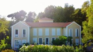 una casa grande con techo rojo y árboles en Villa les Lys en La Seyne-sur-Mer