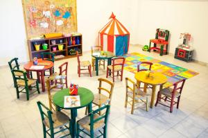 a room with tables and chairs and a play area at Elpida Village in Istro