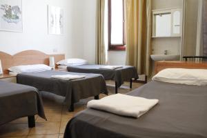 une salle d'hôpital avec trois lits et une baignoire dans l'établissement Hotel Alba, à Milan