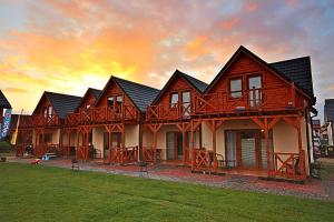 a large house with a sunset in the background at Magija Bałtyku in Sarbinowo