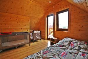 ein Schlafzimmer mit einem Bett in einer Holzhütte in der Unterkunft Magija Bałtyku in Sarbinowo