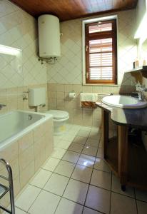 y baño con bañera, lavabo y aseo. en Apartmani Dub, en Cavtat