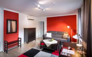 een woonkamer met een bank en rode muren bij Gasthof Silberner Hirsch in Güssing