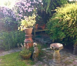 a garden with a vase on a pillar and a bench at Five Saints Farmhouse B&B in Pumpsaint