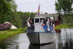 eine Gruppe von Menschen auf einem Boot auf einem Fluss in der Unterkunft Visitor Stugby in Håverud