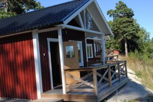 a tiny house with a red and white exterior at Visitor Stugby in Håverud