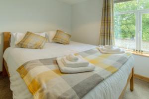 ein Schlafzimmer mit einem Bett mit Handtüchern darauf in der Unterkunft Beach Breeze Cottage - 3 Bed in Caister-on-Sea
