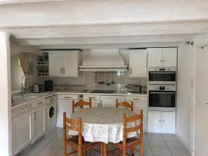 a kitchen with white cabinets and a table and chairs at Le Belvedere in Bandol