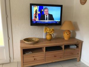 een flatscreen-tv bovenop een houten kast bij Le Belvedere in Bandol