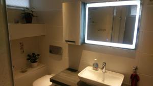 ein Bad mit einem Waschbecken, einem WC und einem Fenster in der Unterkunft Ferienzimmer Familie Schmidt in Großdeuben