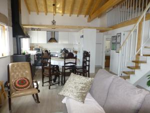 a living room with a couch and chairs and a kitchen at Casa Retiro de Lisei in Penalva do Castelo