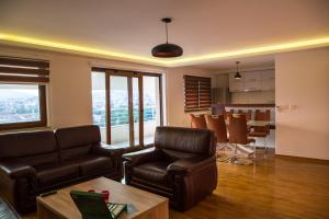- un salon avec des fauteuils en cuir et une table dans l'établissement Villa Sky, à Sarajevo