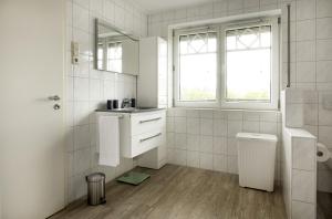 a white bathroom with a sink and a mirror at Luxury Apartment Kampe in Stemwede