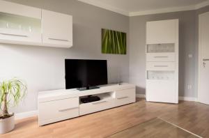 a white entertainment center with a flat screen tv at Luxury Apartment Kampe in Stemwede