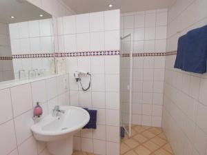 a white bathroom with a sink and a shower at Gästehaus FALKLAY in Burg (an der Mosel)