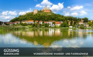 a town on top of a hill next to a body of water at Gasthof Silberner Hirsch in Güssing