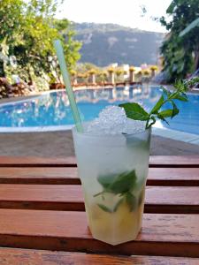 a drink sitting on a wooden table next to a pool at Residence Villaggio Verde in Sorrento