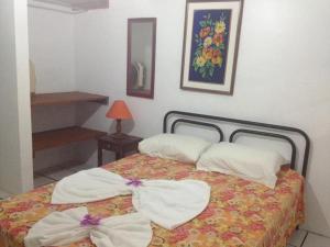 1 dormitorio con 1 cama con toallas en Residencial Ilha das Praias, en Florianópolis