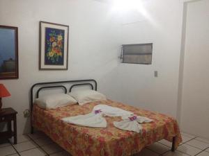 1 dormitorio con 1 cama con toallas en Residencial Ilha das Praias, en Florianópolis