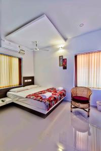a bedroom with a bed and a chair in it at Rams Guest House Near Lulu Mall in Trivandrum