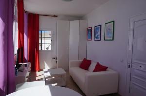 グラン・タラハルにあるApartamento junto el marのリビングルーム(白いソファ、赤いカーテン付)