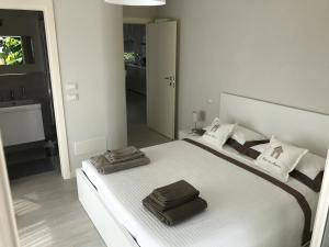 1 dormitorio con 1 cama blanca grande y 2 toallas en Stunning Apartment 300mt from the beach, en Forte dei Marmi