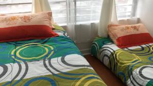 two beds sitting next to each other in a bedroom at Arriendo Diario Iquique in Iquique