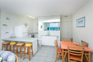 a kitchen and dining room with a table and chairs at Ebbtide 7 in Forster