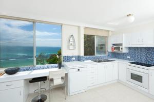 a white kitchen with a view of the ocean at Beachpoint Unit 501 in Forster