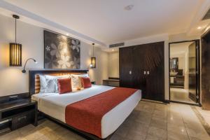 a bedroom with a large bed and a bathroom at The Warwick Fiji in Korolevu