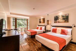 a hotel room with two beds and a television at The Warwick Fiji in Korolevu