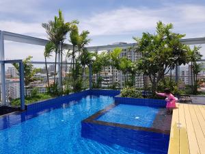 a little girl standing next to a swimming pool on a building at SimplyComfy Apartment by Patsamon in Pattaya South