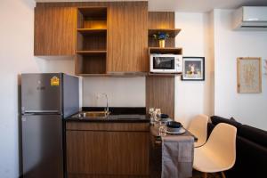 Una pequeña cocina con fregadero y refrigerador. en SimplyComfy Apartment by Patsamon, en Pattaya South