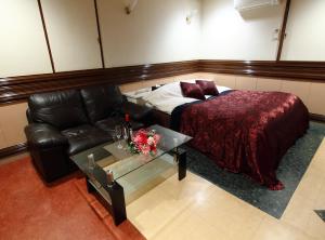 a room with a bed and a couch and a table at Restay Choshi Aine (Adult Only) in Choshi