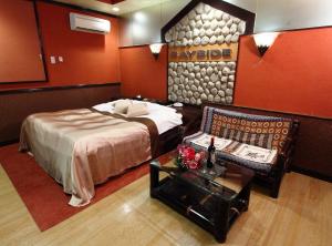 ein Hotelzimmer mit einem Bett und einem Sofa in der Unterkunft Restay Choshi Aine (Adult Only) in Choshi