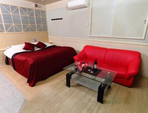 ein Schlafzimmer mit einem roten Bett und einem roten Sofa in der Unterkunft Restay Choshi Aine (Adult Only) in Choshi