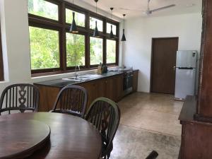 a kitchen with a table and chairs and a refrigerator at Villa by the Lake Bolgoda, Moratuwa-Colombo in Moratuwa