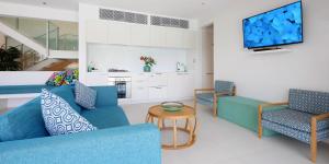 a living room filled with furniture and a tv at Pool Resort Port Douglas in Port Douglas