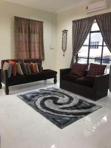 a living room with two couches and a rug at Teratak Tok Wan 1 and 2 in Kota Bharu