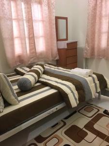 a bedroom with two beds and a window at Teratak Tok Wan 1 and 2 in Kota Bharu