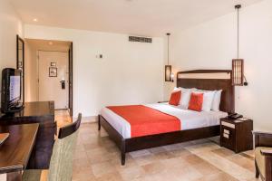 a hotel room with a bed and a television at The Warwick Fiji in Korolevu
