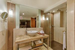 a bathroom with a bowl sink and a shower at Quality Hotel D V Manor in Vijayawāda