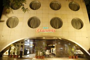 una entrada a un edificio de oficinas con un cartel naranja de hotel en Hotel Orange, en Agra