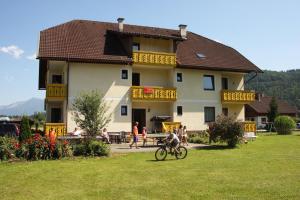 a person riding a bike in front of a building at Apartments Jacqueline in Sankt Kanzian