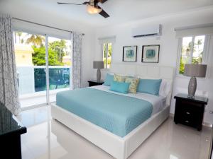 um quarto branco com uma cama e uma janela em The Sanctuary @ Los Corales em Punta Cana