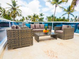 eine Terrasse mit Sofas, einem Tisch und Palmen in der Unterkunft The Sanctuary @ Los Corales in Punta Cana