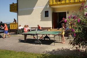 a group of children standing around a ping pong table at Apartments Jacqueline in Sankt Kanzian