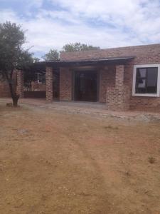 een stenen huis met een tuin ervoor bij Thorntree Lodge in Potchefstroom